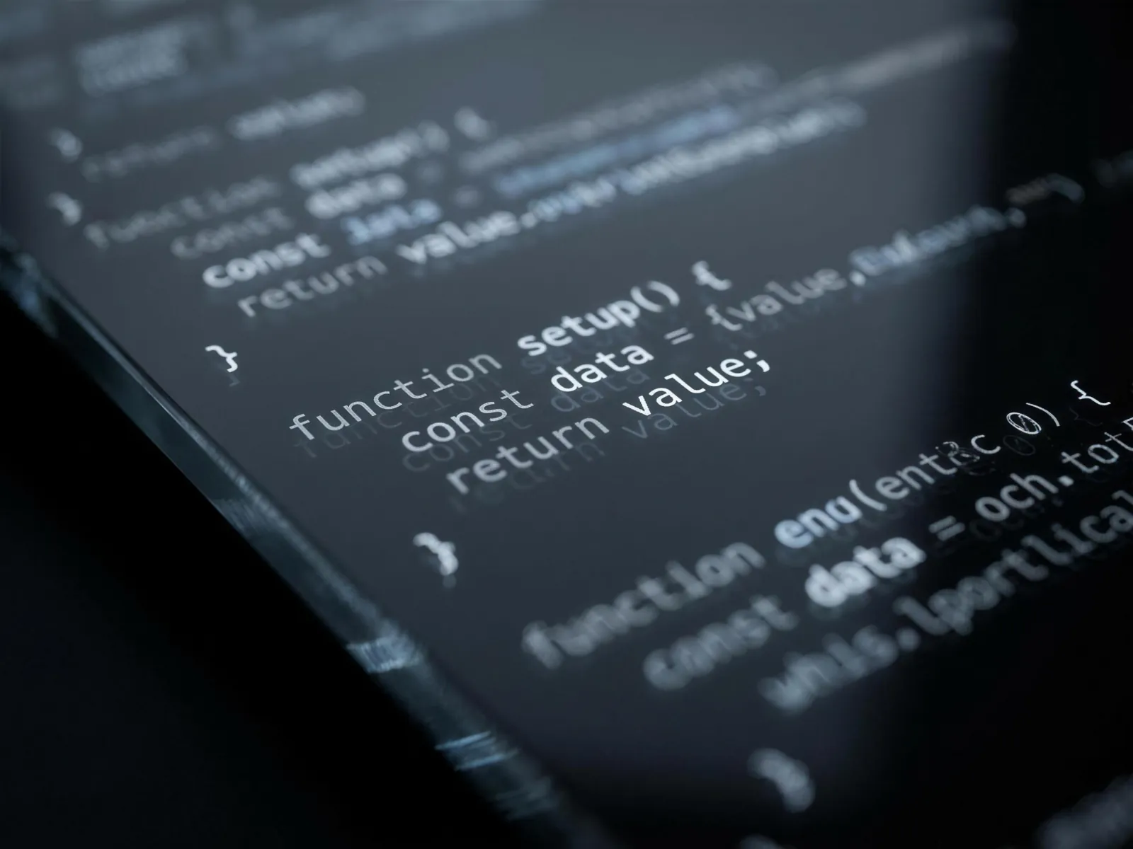 Macro photograph of software code glowing on dark glass